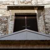 ...sovrastata da un frontone triangolare con una croce in ferro